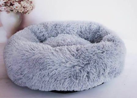 dog curled up inside plush donut bed